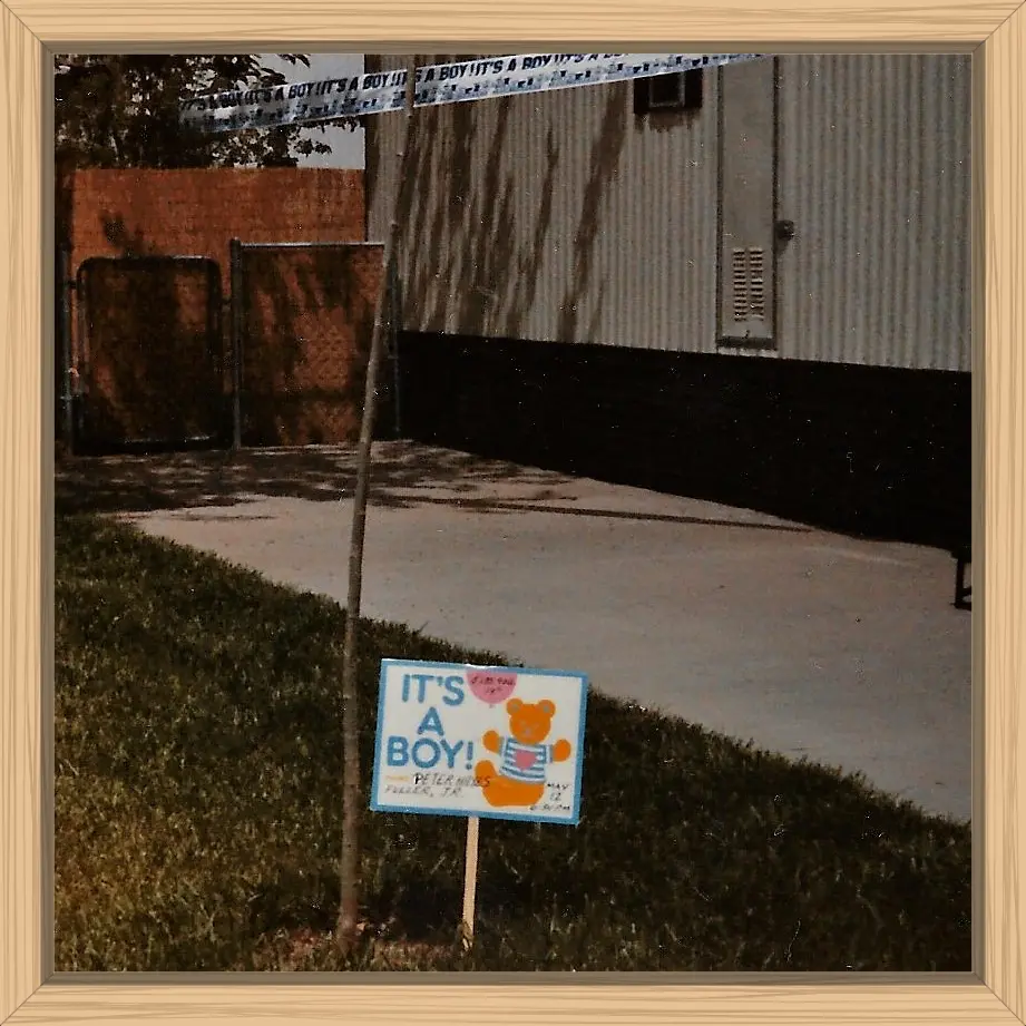 The front yard of our mobile home with the It's A Boy sign and banner.