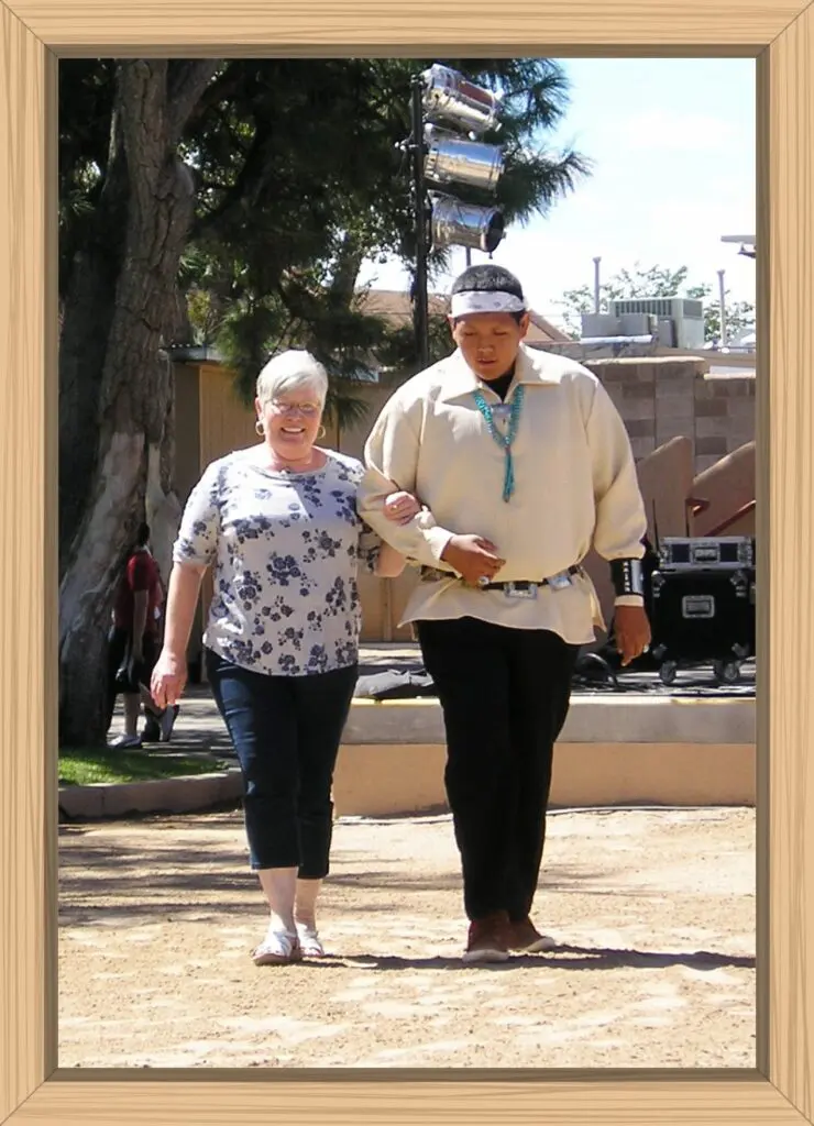 My sister and one of the Native dancers walking arm in arm for The Friendship Dance.