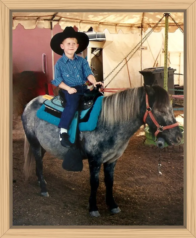 Hayes all decked out in his black cowboy hat and Western blue shirt on top of a beautiful pony at the New Mexico State Fair.