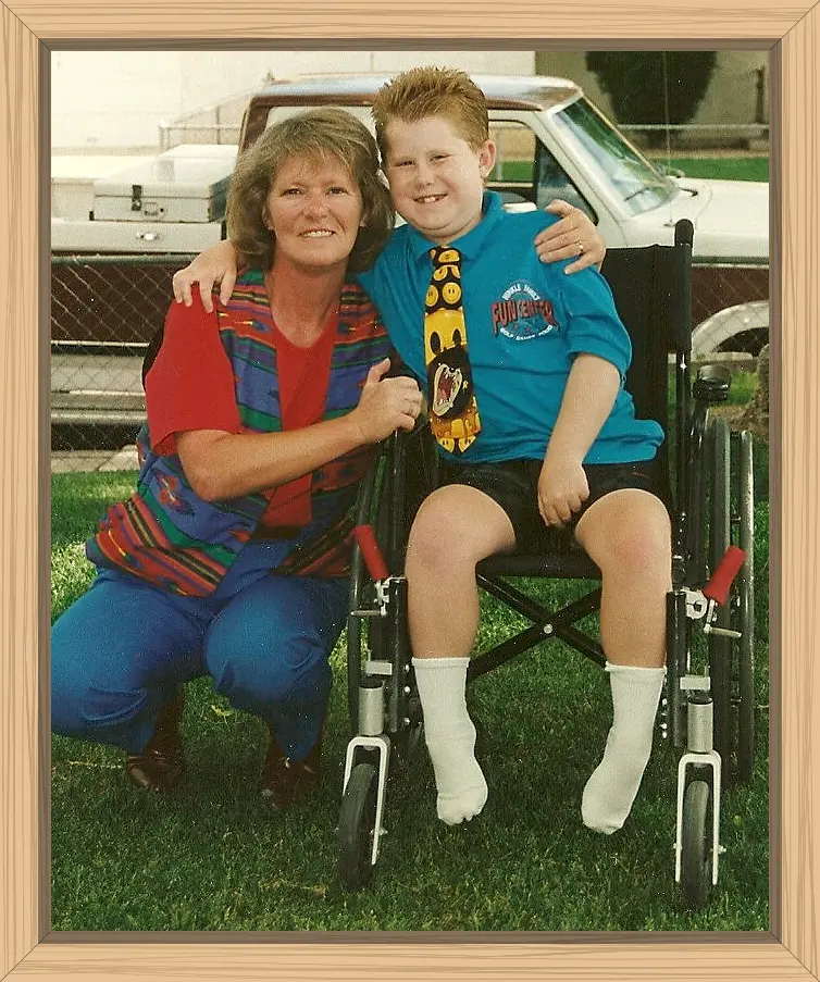 Hayes is in a manual wheelchair, and we are hugging each other in the front yard.