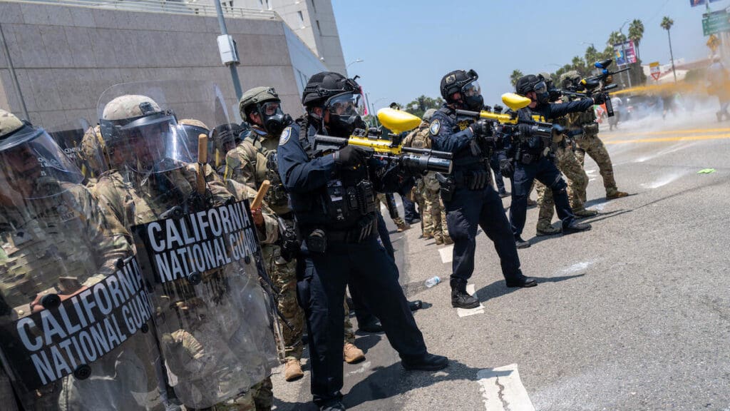 A group of police officers and the National Guard firing rubber bullets at unarmed citizens during a protest.